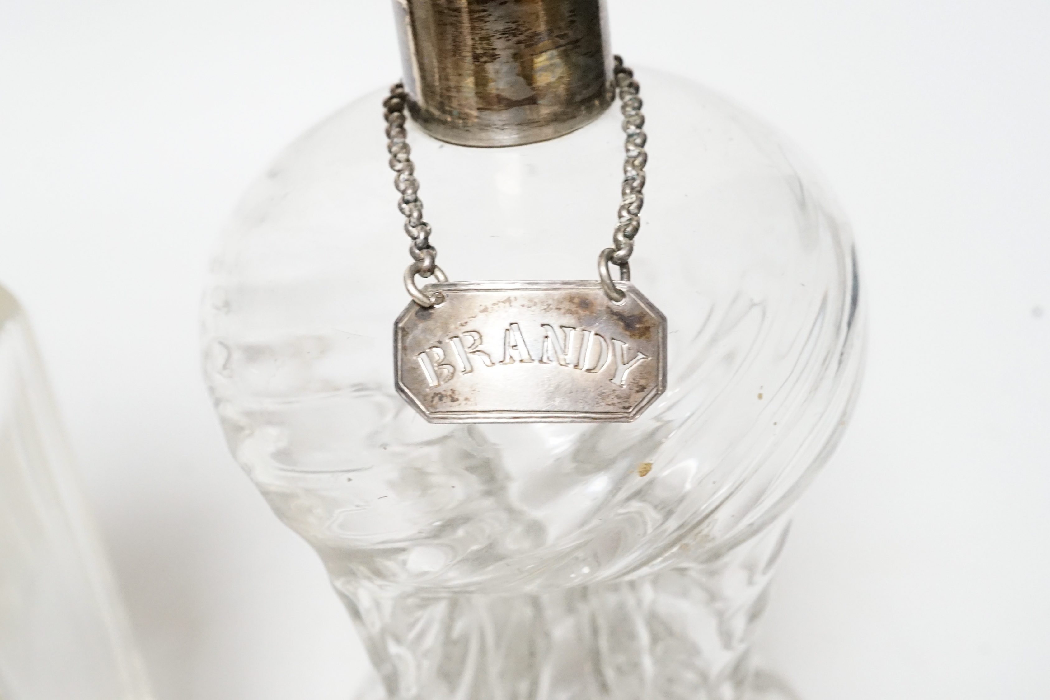 A silver mounted glass decanter with silver ‘BRANDY’ label and another